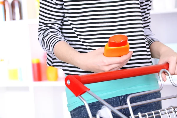 Mulher com carrinho no supermercado close-up — Fotografia de Stock