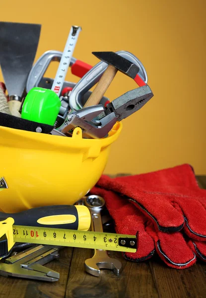 Construction equipment on wooden table, on color background — Stock Photo, Image