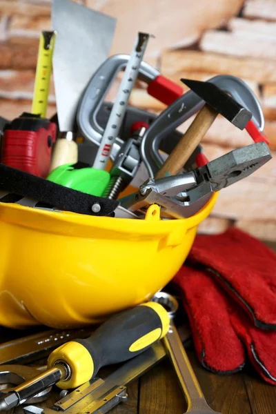 Construction equipment on wooden table on wall background — Stock Photo, Image