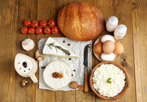 Stilleven met zuivelproducten en brood op houten tafel — Stockfoto
