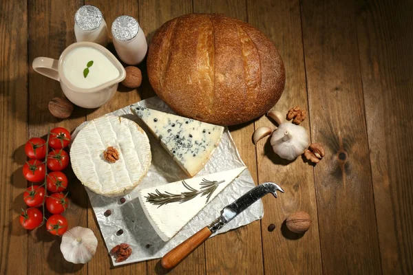 Натюрморт с молочными продуктами и хлебом на деревянном столе — стоковое фото