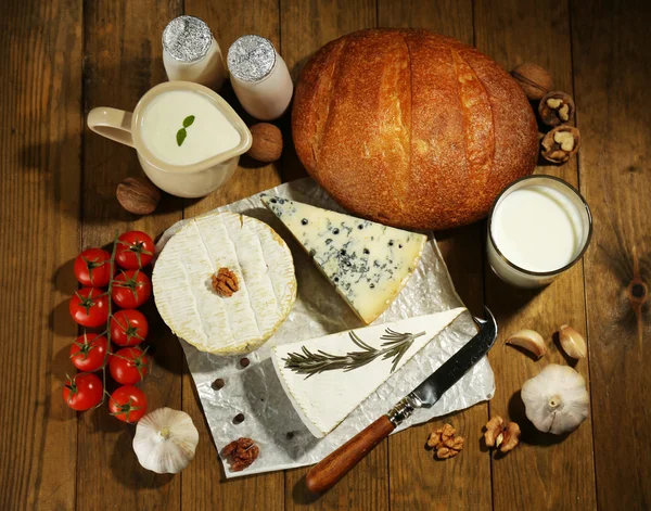Zátiší s mléčnými výrobky a chleba na dřevěný stůl — Stock fotografie