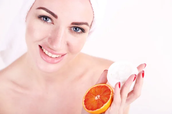 Mulher bonita segurando laranja e tigela com creme, isolado em branco — Fotografia de Stock
