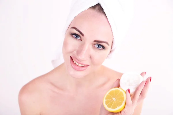 Mulher bonita segurando limão e tigela com creme, isolado em branco — Fotografia de Stock