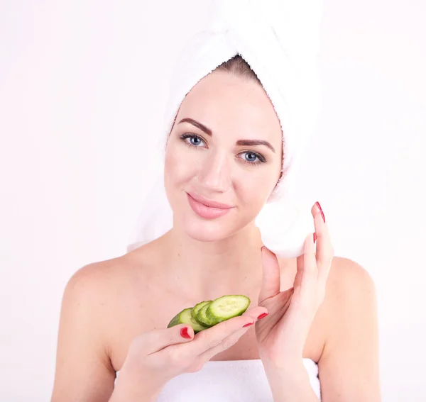 Güzel genç bir kadın tutarak taze salatalık dilimleri ve bir kase krem, beyaz izole — Stok fotoğraf