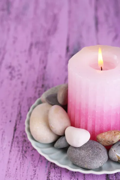 Samenstelling met spa stenen, kaars op de houten tafel kleur op lichte achtergrond — Stockfoto