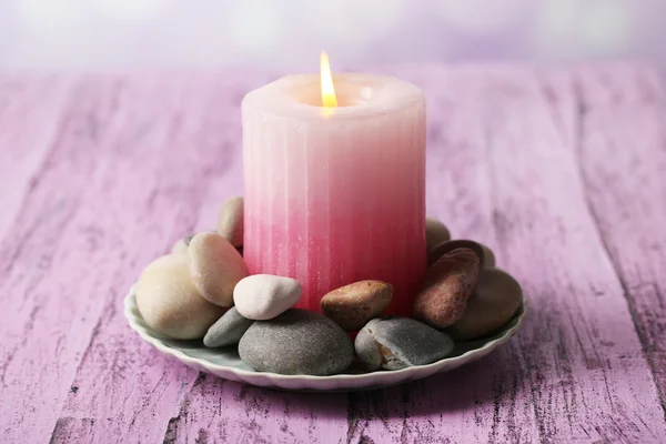 Composición con piedras de spa, vela sobre tabla de madera de color, sobre fondo claro — Foto de Stock