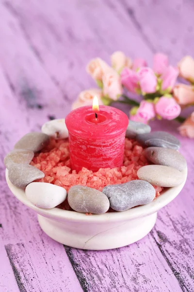 Composición con piedras de spa, velas y flores sobre fondo de mesa de madera de color — Foto de Stock