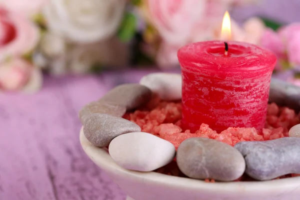 Composition with spa stones, candle  and flowers on color wooden table background — Stock Photo, Image