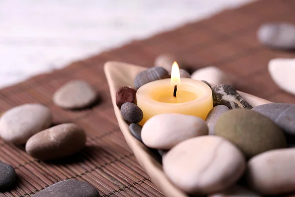 Composition with spa stones, candles on bamboo mat background — Stock Photo, Image