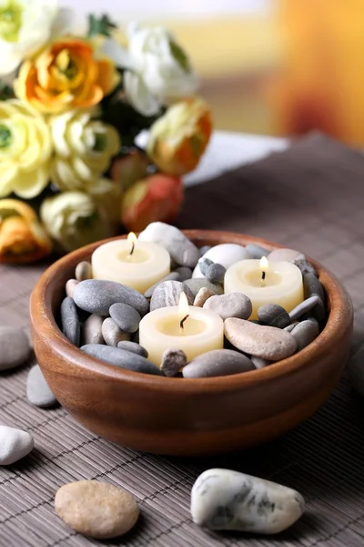 Composition with spa stones, candles  and flowers on  bamboo mat, on  bright background — Stock Photo, Image