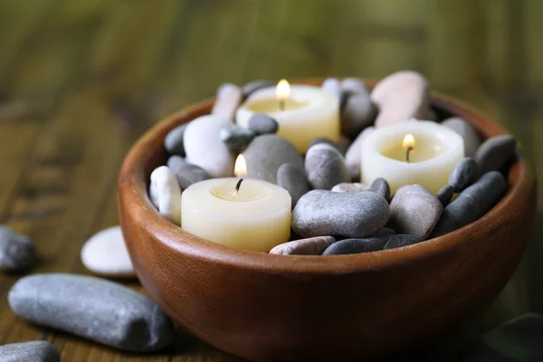 Composição com pedras de spa, velas sobre fundo de madeira — Fotografia de Stock