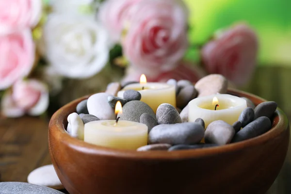 Samenstelling met spa stenen, kaarsen en bloemen op lichte achtergrond — Stockfoto