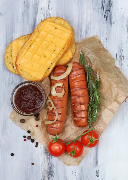 Gegrilde worstjes op houten tafel — Stockfoto