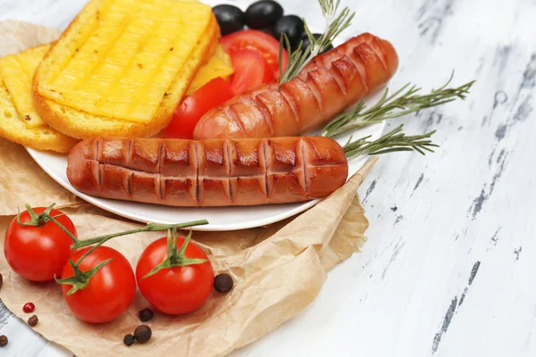 Salsichas grelhadas na mesa de madeira — Fotografia de Stock