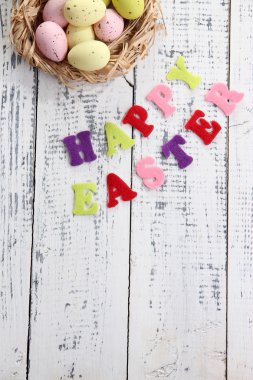 Paskalya yumurta yuva ve renk ahşap zemin üzerine işaret
