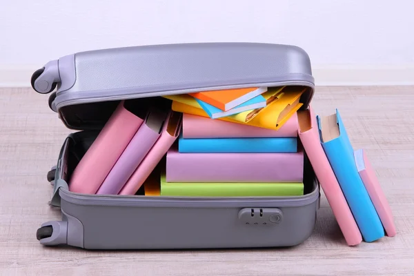 Books in suitcase on wall background — Stock Photo, Image