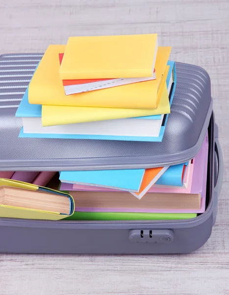 Books in suitcase on wall background — Stock Photo, Image