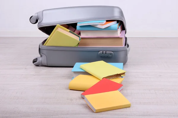 Books in suitcase on wall background — Stock Photo, Image