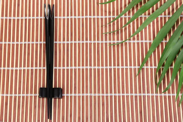 Palillos sobre fondo de estera de bambú — Foto de Stock