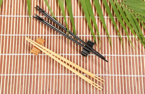 Bastoncini su sfondo tappetino di bambù — Foto Stock