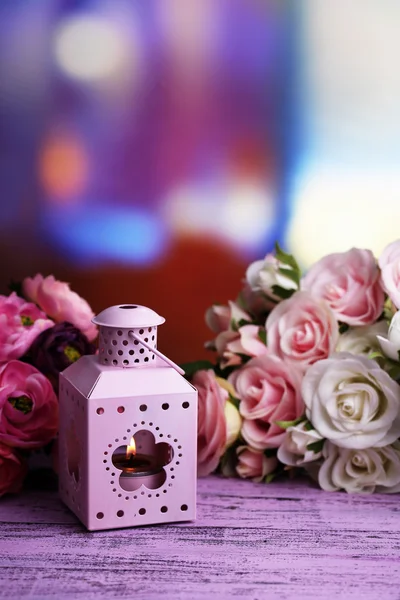 Ozdobné kovové lucerny a umělé květiny na světlé pozadí — Stock fotografie