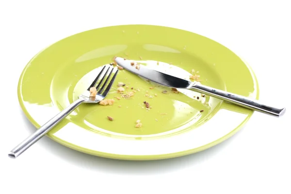 Plate with crumbs and used fork and knife, close-up, on white background — Stock Photo, Image