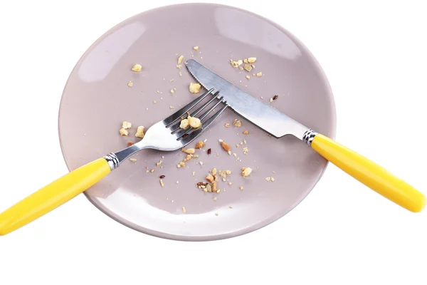 Plate with crumbs and used fork and knife, close-up, on white background — Stock Photo, Image