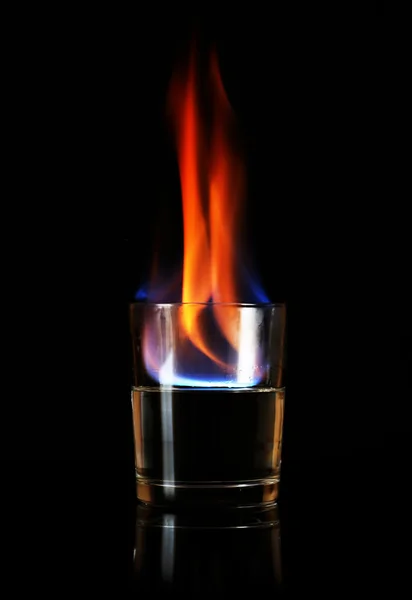 Glass with burning alcohol on black background — Stock Photo, Image