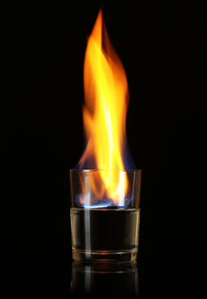 Glass with burning alcohol on black background — Stock Photo, Image