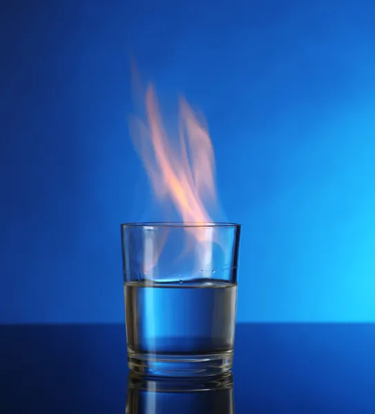 青色の背景にアルコールを燃焼とガラス — ストック写真