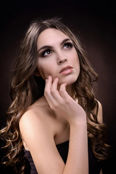 Beautiful young woman with long hair on dark brown background — Stock Photo, Image