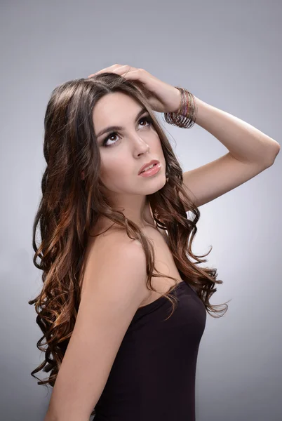 Mulher bonita com cabelos longos no fundo cinza — Fotografia de Stock