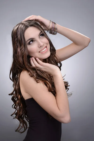 Piękna młoda kobieta z długimi włosami na szarym tle — Zdjęcie stockowe