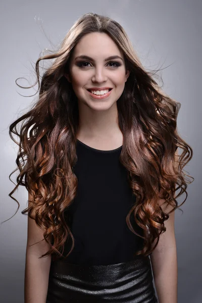 Beautiful young woman with long hair on grey background — Stock Photo, Image