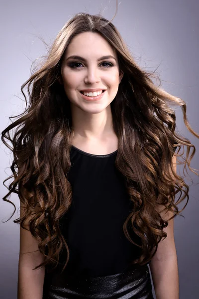 Beautiful young woman with long hair on grey background — Stock Photo, Image