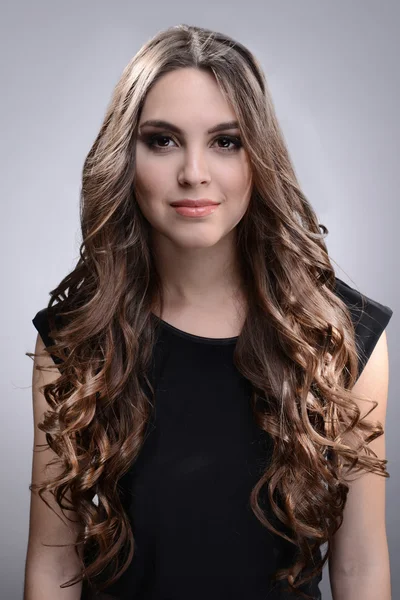 Hermosa joven con el pelo largo sobre fondo gris —  Fotos de Stock