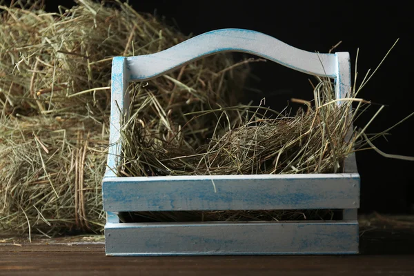 Hay in wooden crate, on dark background — 图库照片