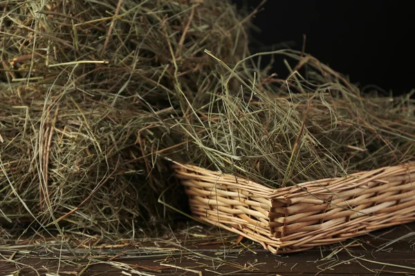 Hay in wicker basket, on dark background — Stock Photo, Image