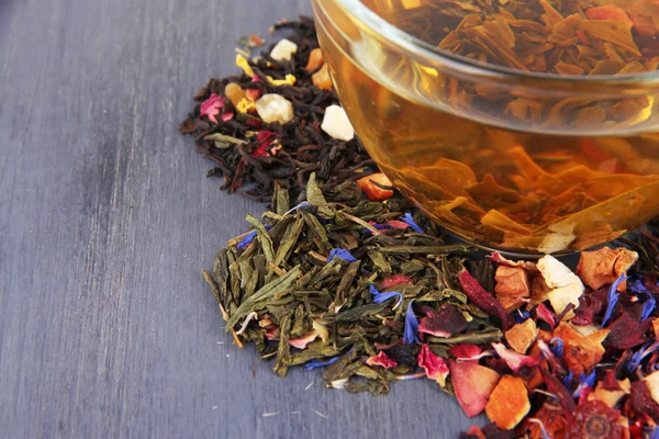 Xícara de chá com chá seco aromático em fundo de madeira — Fotografia de Stock