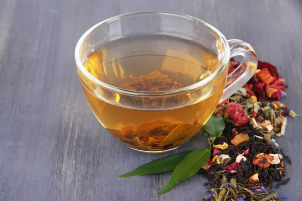 Cup of tea with aromatic dry tea on wooden background — Stock Photo, Image