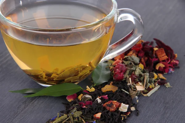 Tasse de thé avec thé sec aromatique sur fond en bois — Photo