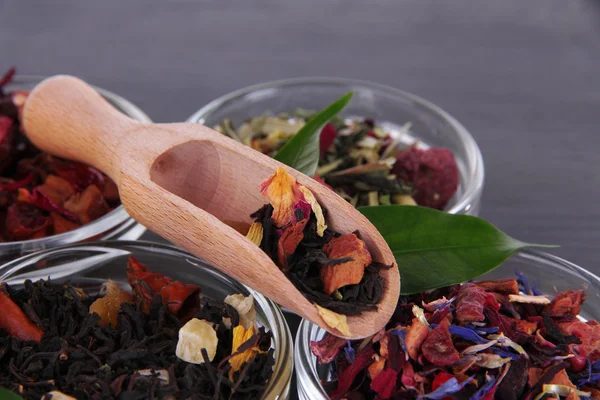 Aromatische droge thee in kommen op houten achtergrond — Stockfoto