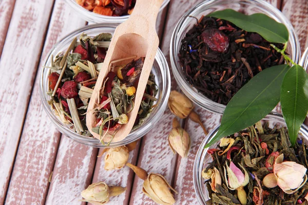 Té seco aromático en cuencos sobre fondo de madera —  Fotos de Stock