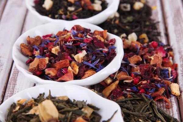Aromatiska torr te i skålar på trä bakgrund — Stockfoto