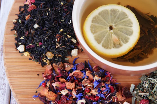 Taza de té con té seco aromático en soporte de madera de cerca — Foto de Stock