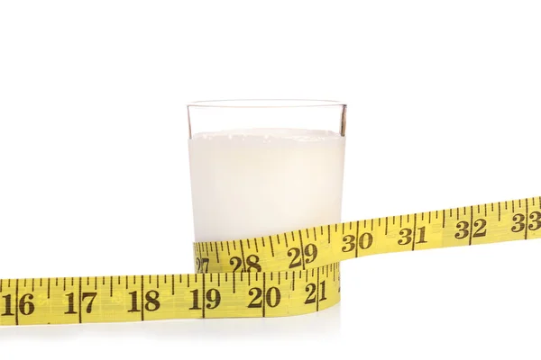 Glass of milk with measuring tape isolated on white — Stock Photo, Image