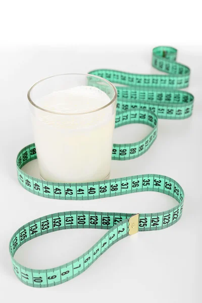 Glass of milk with measuring tape isolated on white — Stock Photo, Image