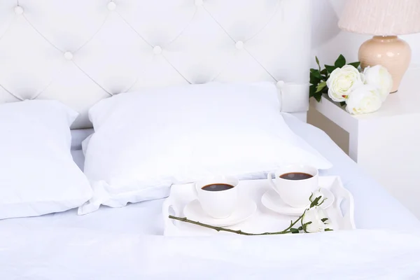 Kopjes koffie op de comfortabele zachte bed met kussens — Stockfoto