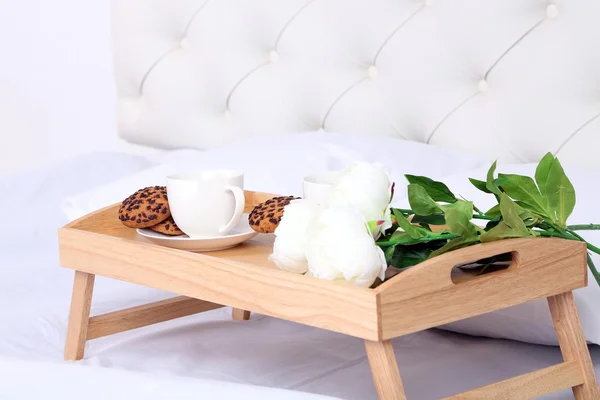 Šálky kávy na pohodlné měkké posteli s polštáři — Stock fotografie